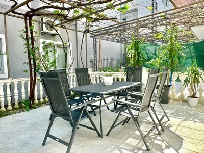 a table and chairs on a patio with plants at Family One bedroom apartment Marijana in Budva