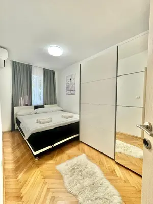 a bedroom with a bed and a large closet at Family One bedroom apartment Marijana in Budva