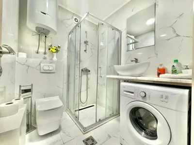 a white bathroom with a washing machine and a shower at Family One bedroom apartment Marijana in Budva