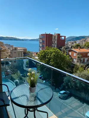 a glass table on a balcony with a view of the water at Vanja apartment Przno in Budva