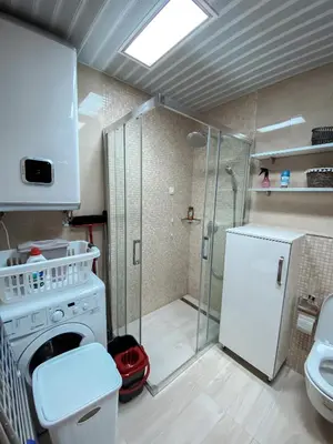 a bathroom with a shower and a white refrigerator at Vanja apartment Przno in Budva