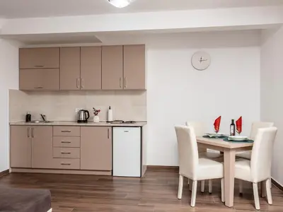 a kitchen and dining room with a table and chairs at Apartments 4U in Dobra Voda