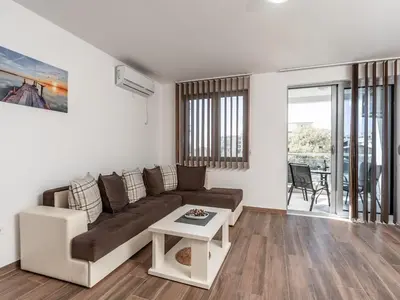 a living room with a couch and a table at Apartments 4U in Dobra Voda
