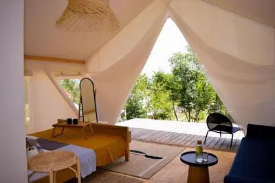 a bedroom with a bed in a tent at Oblun Eco Resort - New Glamping Tents near Lake Skadar in Podgorica