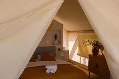 a bedroom with a bed in a attic at Oblun Eco Resort - New Glamping Tents near Lake Skadar in Podgorica
