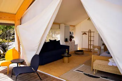 a living room with a blue couch in a tent at Oblun Eco Resort - New Glamping Tents near Lake Skadar in Podgorica