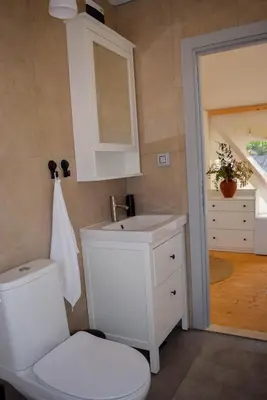 a white bathroom with a toilet and a sink at Oblun Eco Resort - New Glamping Tents near Lake Skadar in Podgorica