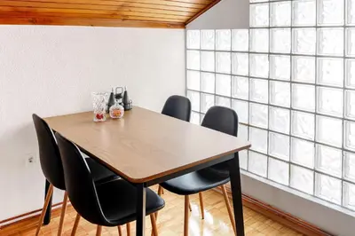 a dining room with a wooden table and black chairs at Apartment Busola in Kotor