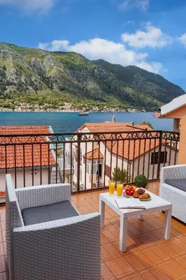 a balcony with a table with fruit and drinks on it at Apartment Busola in Kotor