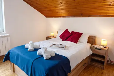 a bedroom with a large bed with red pillows at Apartment Busola in Kotor