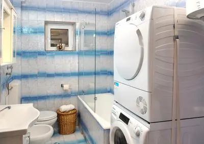 a bathroom with a toilet sink and a washing machine at Apartment Busola in Kotor