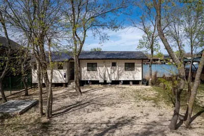 a house with a lot of trees in front of a lake at Bel Assis in Ulcinj
