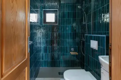 a green tiled bathroom with a toilet and a sink at Bel Assis in Ulcinj
