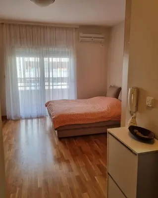a bedroom with a bed and a large window at Studio apartment Vito in Podgorica