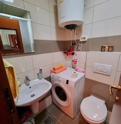 a bathroom with a washing machine and a sink at Studio apartment Vito in Podgorica