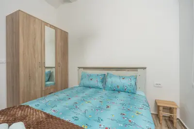 a bedroom with a blue bed with a wooden cabinet at Jasen Apartments Lakeview in Virpazar
