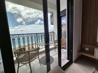 a balcony with a table and chairs and a view of the ocean at Skyline Apartments in Dobra Voda