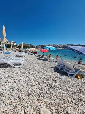 a group of chairs and umbrellas on a beach at Skyline Apartments in Dobra Voda