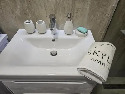 a white bathroom sink with a towel on it at Skyline Apartments in Dobra Voda