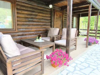 a porch with chairs and a table and flowers at Virpazar Oaza in Virpazar
