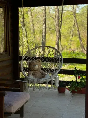 a teddy bear sitting in a swing on a porch at Virpazar Oaza in Virpazar