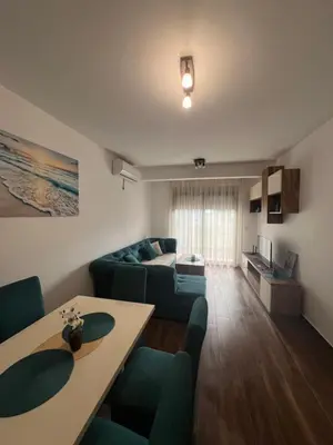a living room with a couch and a table at Oceans Apartman in Dobra Voda