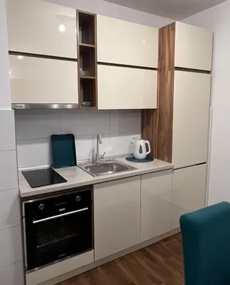 a small kitchen with white cabinets and a sink at Oceans Apartman in Dobra Voda