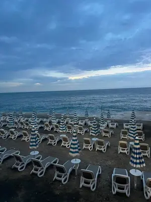 a group of chairs and tables on a beach at Oceans Apartman in Dobra Voda
