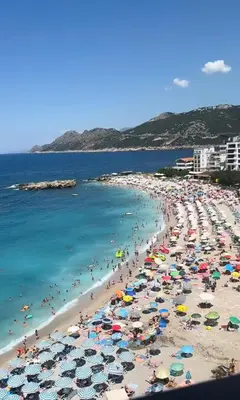 a beach filled with lots of people and umbrellas at Oceans Apartman in Dobra Voda