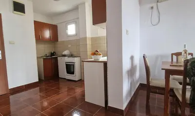 a small kitchen with a counter and a table at Evropa Lux Apartments in Budva
