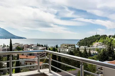a balcony with a view of a city and the ocean at Evropa Lux Apartments in Budva
