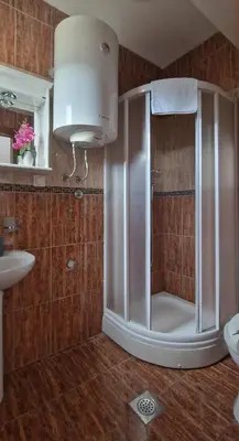 a bathroom with a shower with a toilet and a sink at Evropa Lux Apartments in Budva
