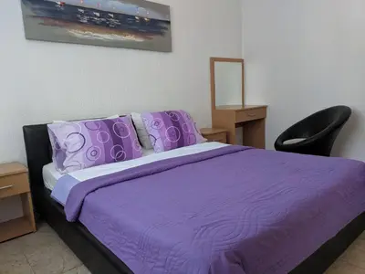 a bedroom with a purple bed and a chair at Beni Bungalows in Ulcinj
