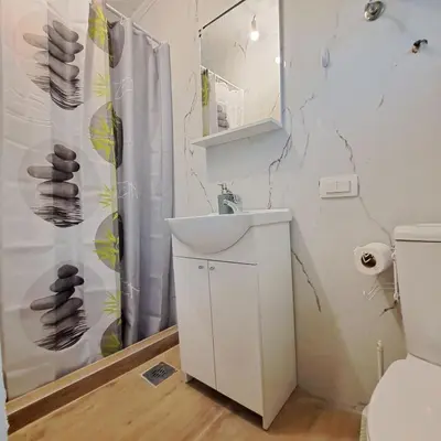 a bathroom with a sink and a shower curtain at Unique Apartment Centar in Podgorica