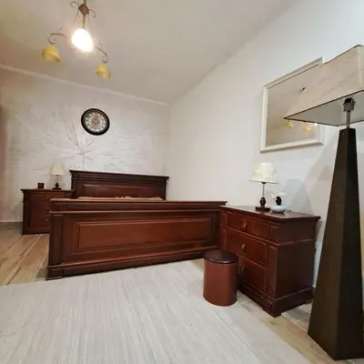 a bedroom with a bed and a clock on the wall at Unique Apartment Centar in Podgorica
