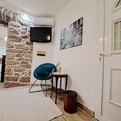 a room with a blue chair and a small table at Unique Apartment Centar in Podgorica