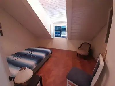 a bedroom with a bed and a chair and a window at Beach edge 4-Bed House in Muo Kotor in Kotor