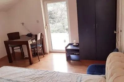 a bedroom with a bed and a desk with a computer at 2-level apartment with terraces by the sea in Budva