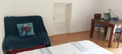a bedroom with a desk and a chair with a pillow at 2-level apartment with terraces by the sea in Budva