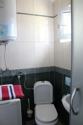 a small bathroom with a toilet and a sink at 2-level apartment with terraces by the sea in Budva