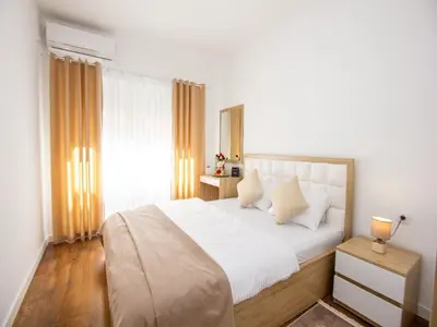 a bedroom with a large bed with white sheets at Apartment Ochsen in Ulcinj