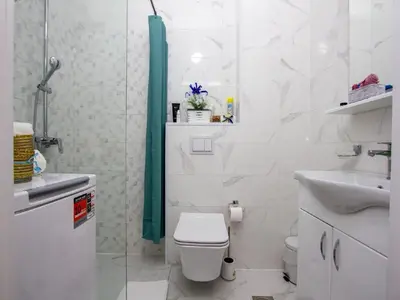 a white bathroom with a toilet and a sink at Apartment Ochsen in Ulcinj