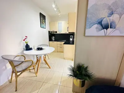 a living room with a table and a kitchen at Design studio in Petrovac in Petrovac na Moru