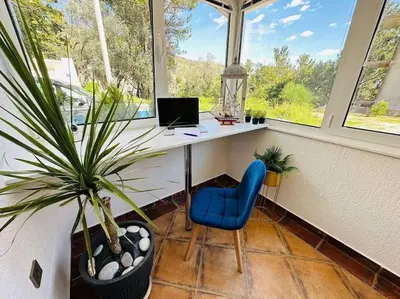 a office with a desk and a blue chair and a plant at Design studio in Petrovac in Petrovac na Moru