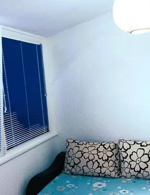 a room with a bed with a window and a pillow at Design studio in Petrovac in Petrovac na Moru