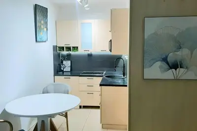 a kitchen with a table and a white table at Design studio in Petrovac in Petrovac na Moru