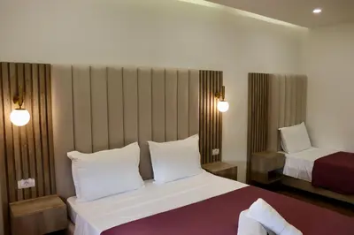 a hotel room with a bed and a chair at Villa Cataleya in Ulcinj