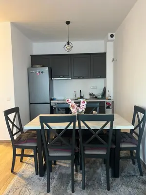 a kitchen with a table with chairs and a refrigerator at Apartman Tara in Ulcinj