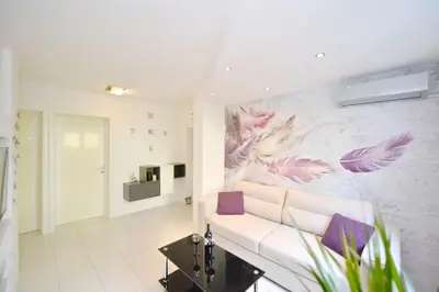 a living room with a white couch and a painting on the wall at Majestic Suite,800m to Old town&minutes to seaside in Kotor