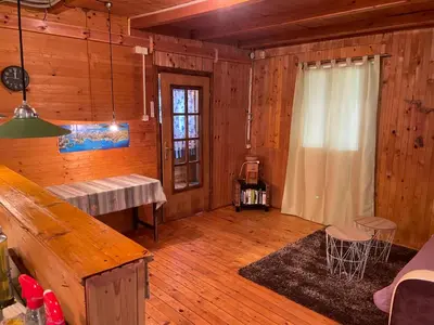 a living room with wooden walls and wooden floors at Tobis hostel in Ulcinj
